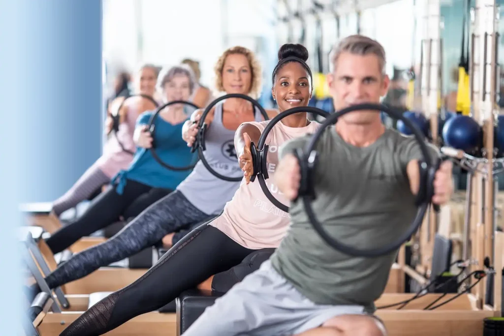 Grupo diverso practicando Pilates con máquinas y aro en Club Pilates Indautxu Bilbao